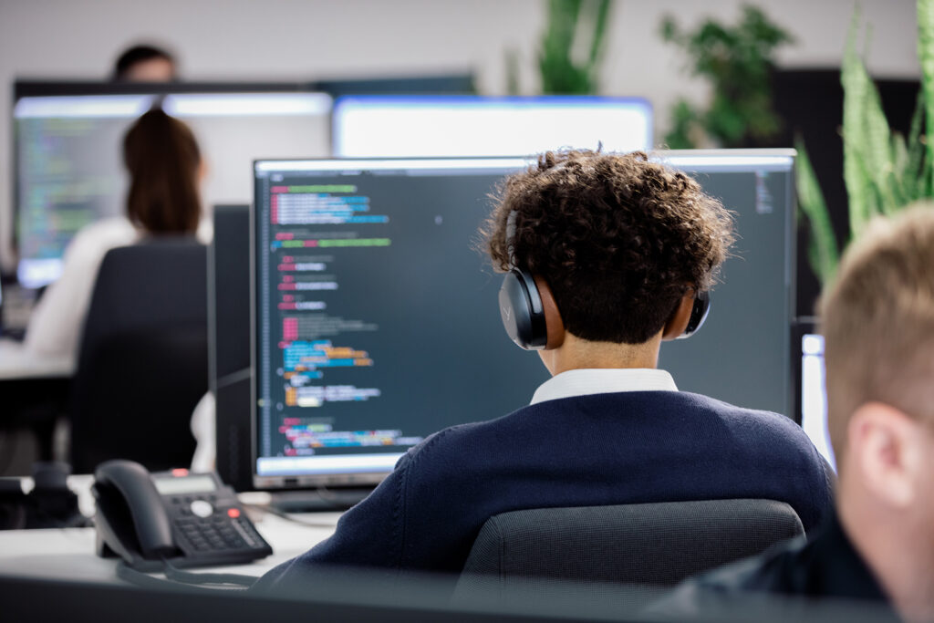 Programmierer des Typo3Werk bei der Arbeit Junger Mann sitzt vor seinem PC und programmiert.