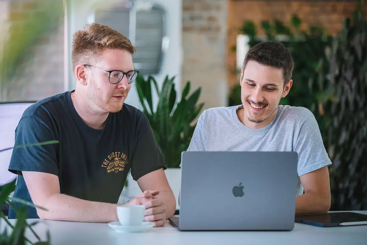 Gespräch zwischen zwei TYPO3-Experten vor einem Notebook