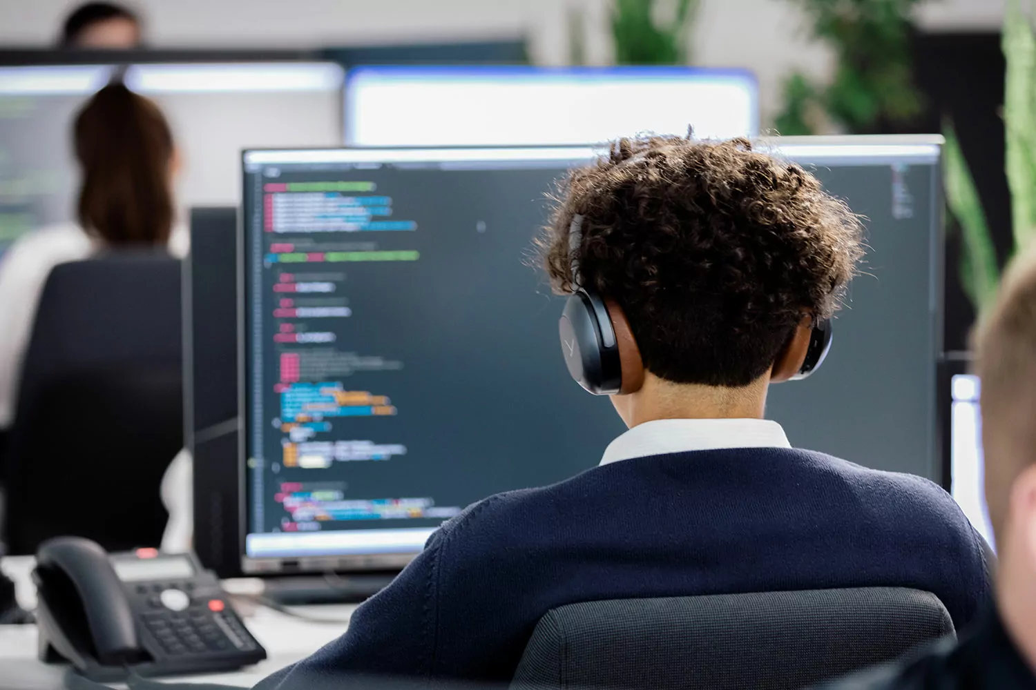 Programmierer des Typo3Werk bei der Arbeit Junger Mann sitzt vor seinem PC und programmiert.